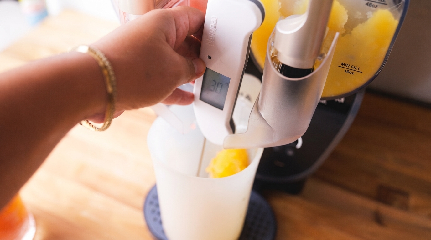 A modern slushie machine on a kitchen counter, creating colorful frozen drinks for a party, showcasing ease and fun for home entertaining.